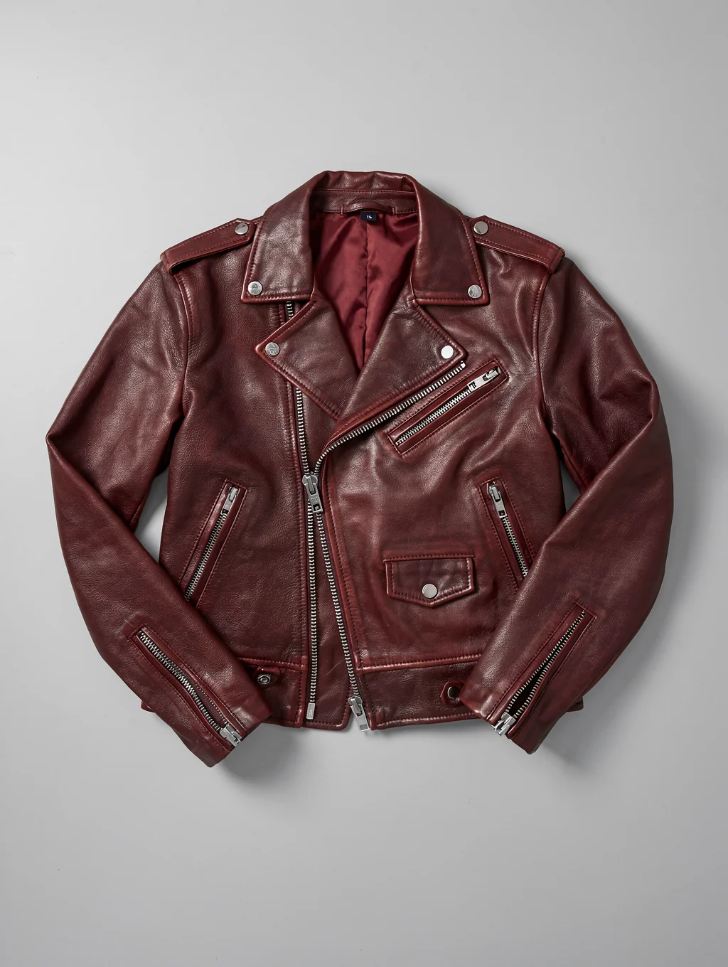 Contemporary apparel and refined leather lifestyle accessories arranged on minimalist obsidian surface
